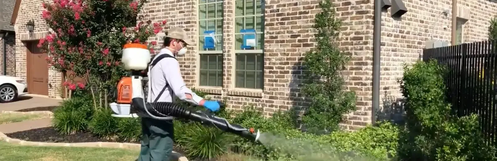 EntoLogic technician applying mosquito barrier spray to yard vegetation